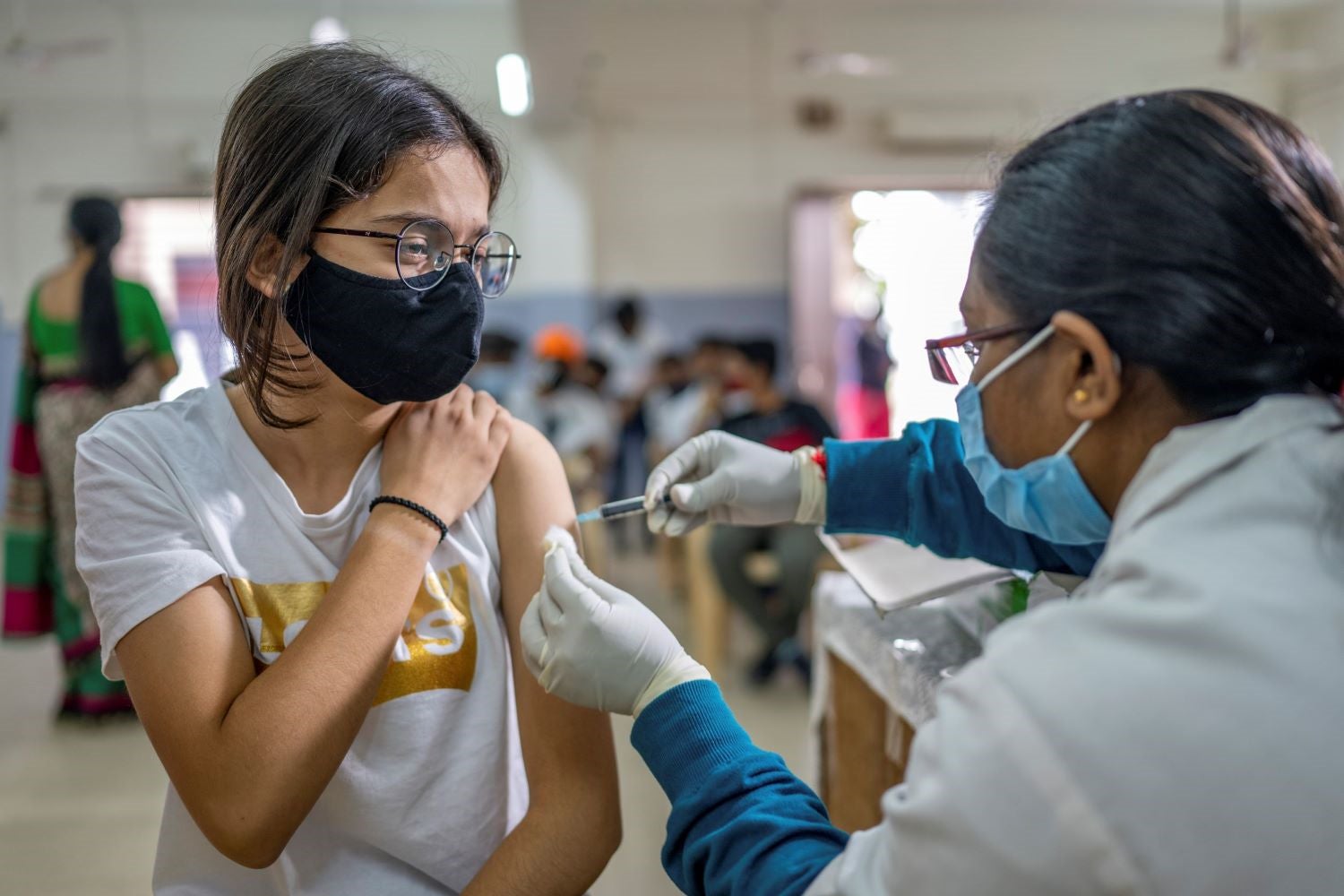 Female receives a vaccination in her arm.