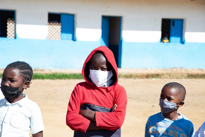 Samy, 11, listens carefully to UNICEF worker about preventive care during the Ebola 2026 outbreak.