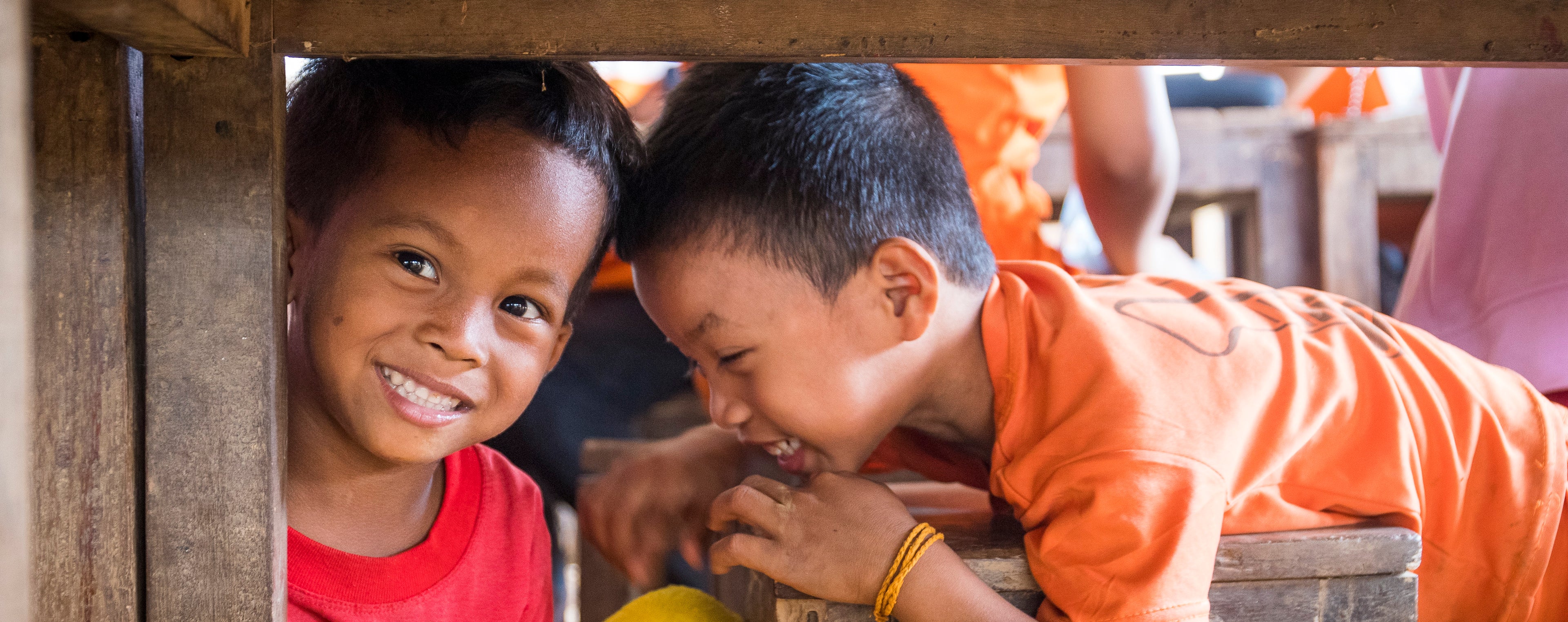 Two boys in Laos playing under table