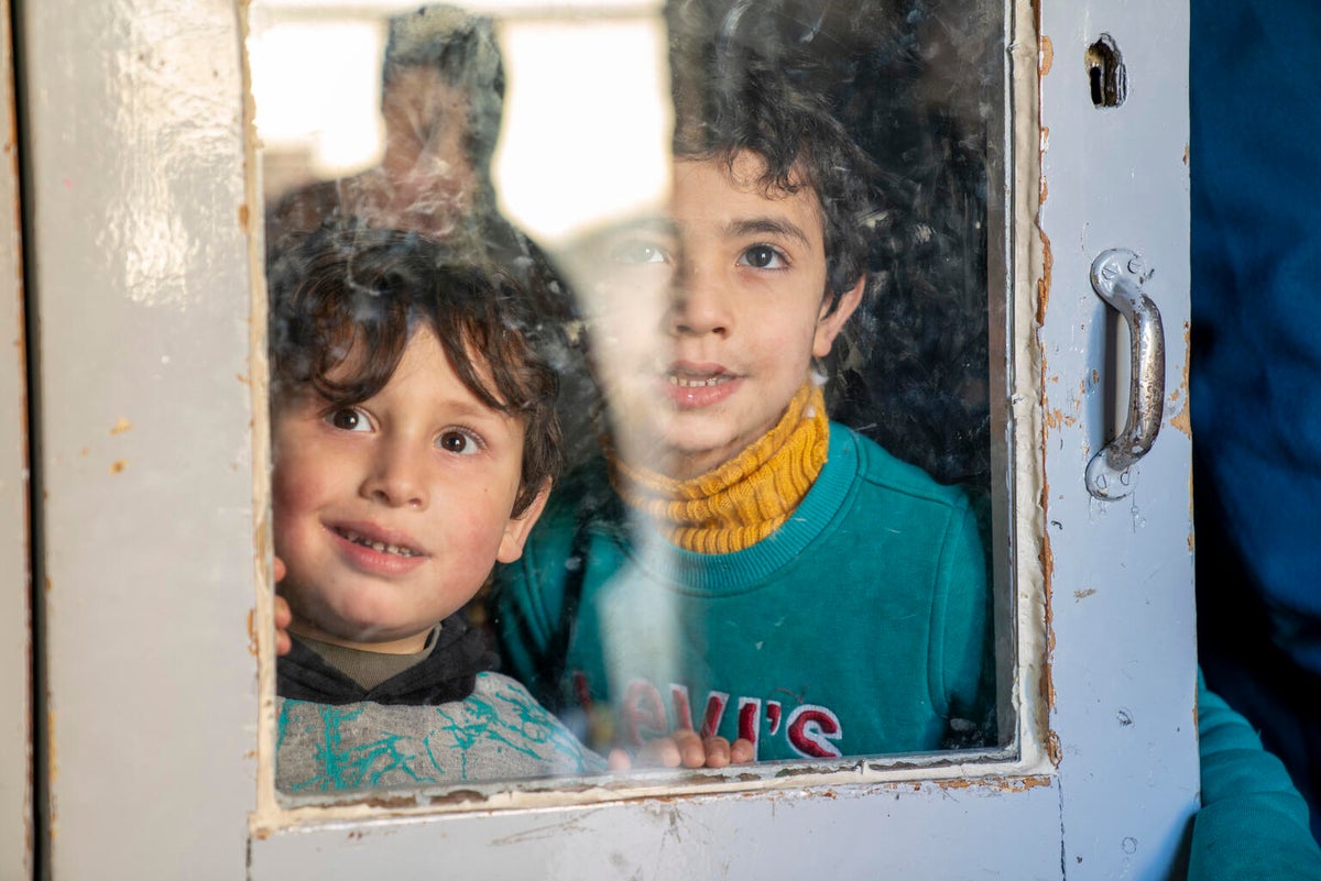 Children gaze out of the glass door of a mosque-turned-collective-shelter in Sleiman Alhalabi neighbourhood, Aleppo city, north Syria. 