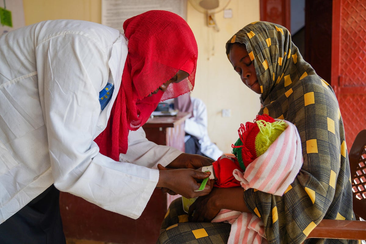 Fadeela, a nutritionist at a UNICEF-supported health facility, assesses a baby for acute malnutrition.