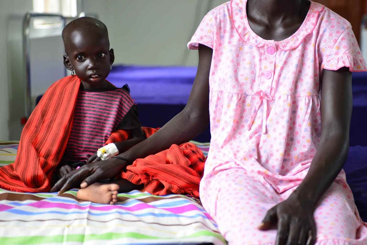 Nyabol Hion sits next to her daughter Nyanmot at the Al-Shabbah Children’s Hospital in Juda, South Sudan in 2014.