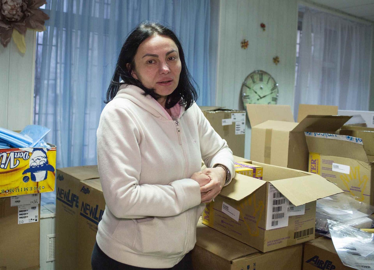Female stands in front of supply boxes in a health care centre