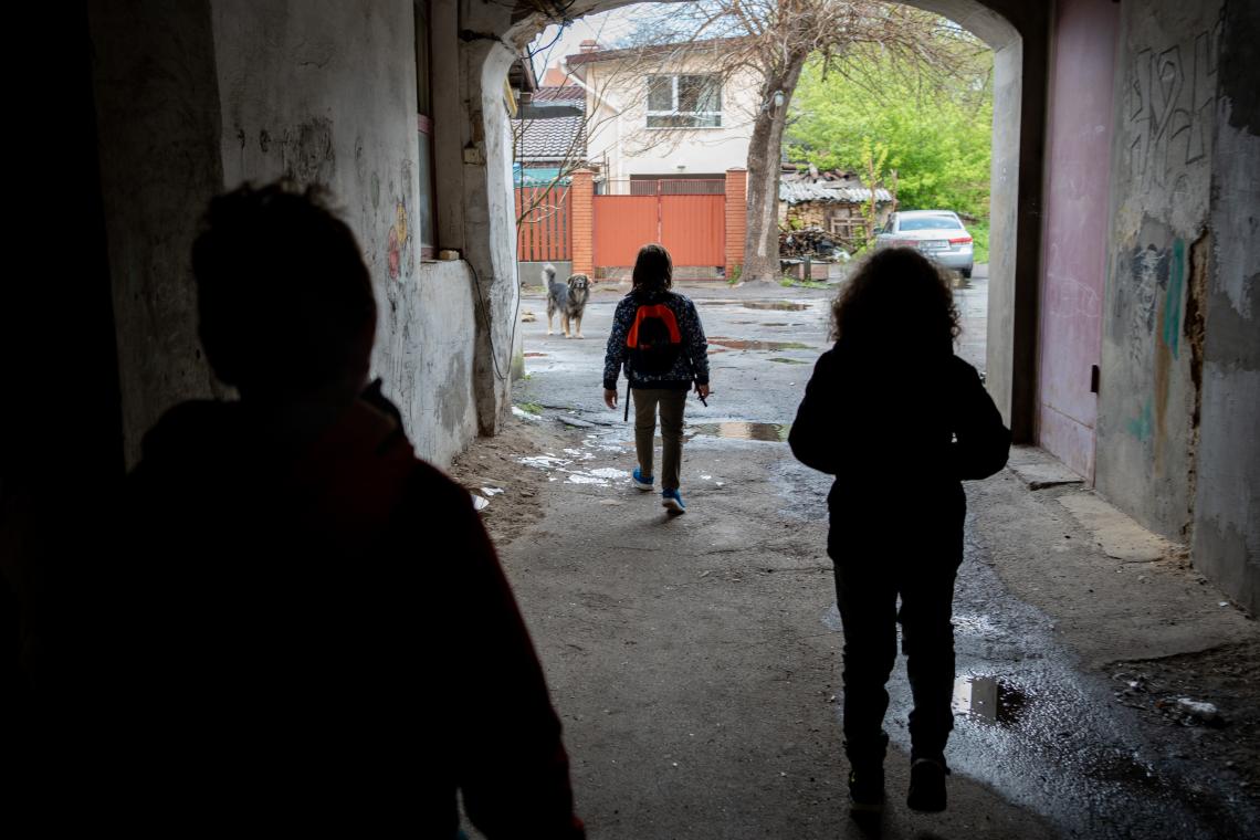 Three brothers walk through the yard in their home. 