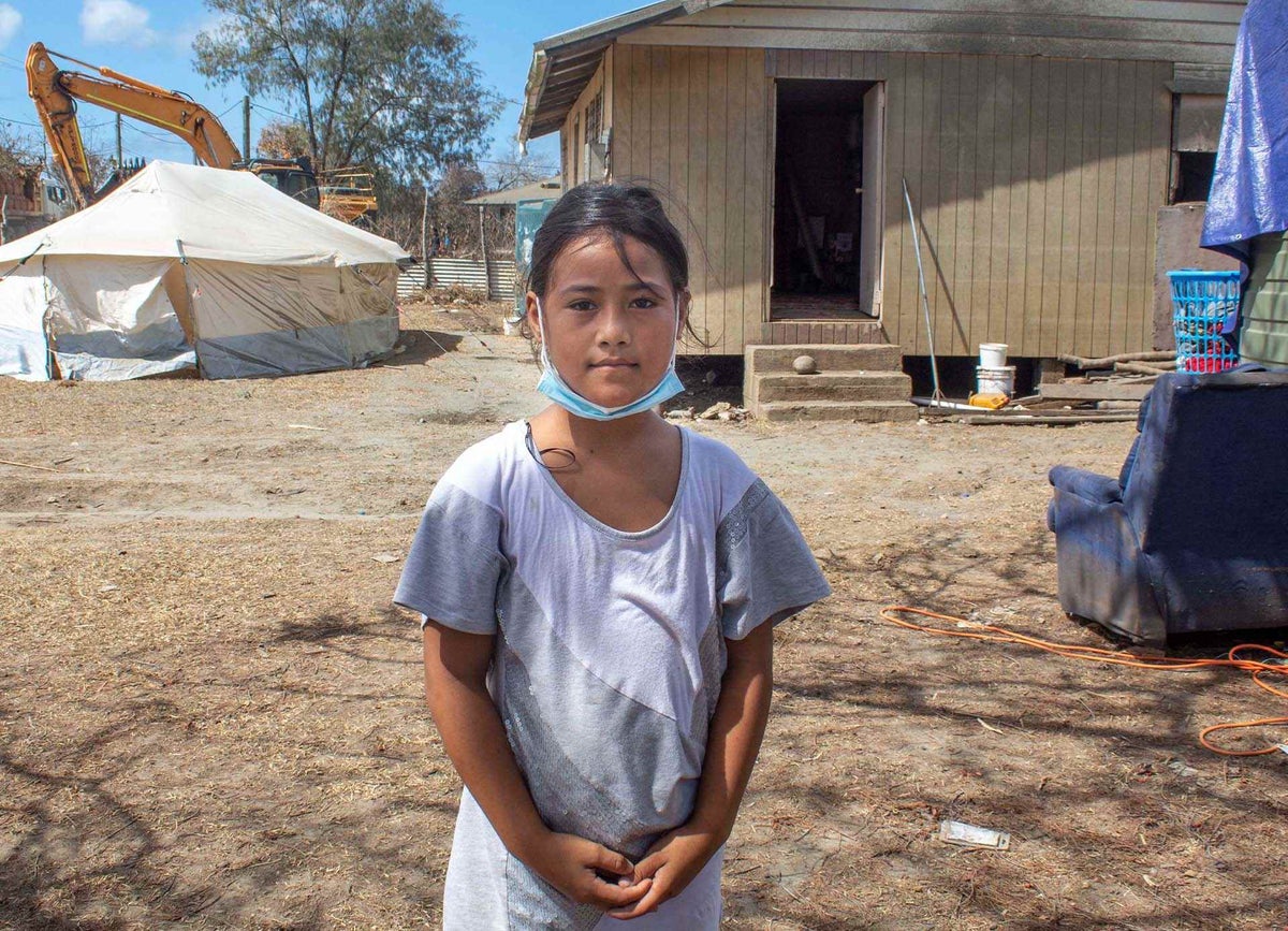 Ma'ata, 10, stands in front of her home on Tongatapu, Tonga’s main island, showing damaged caused by the volcanic eruption and tsunami. 
