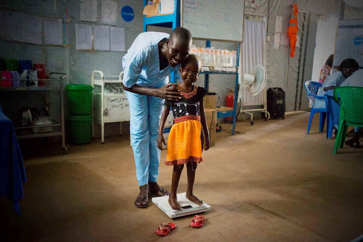 A young girl standing on scales at a healthcare clinic