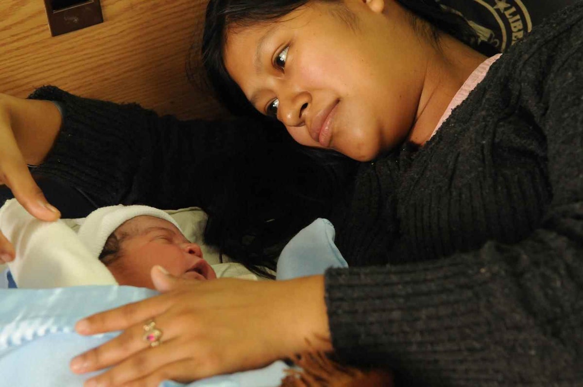 Saundy Sagui, an indigenous Mayan woman, cradles her newborn son in Cobán, Guatemala in 2012. 