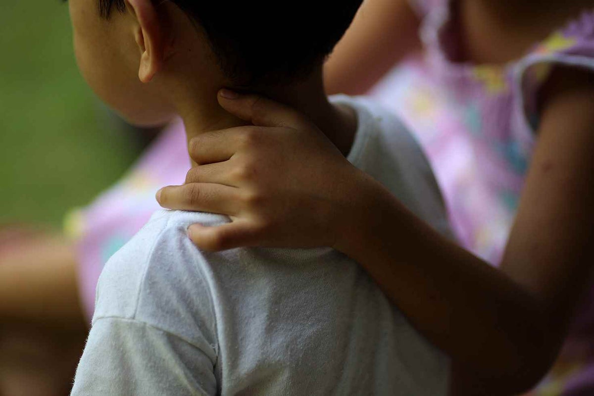 Young boy with an arm on his shoulder