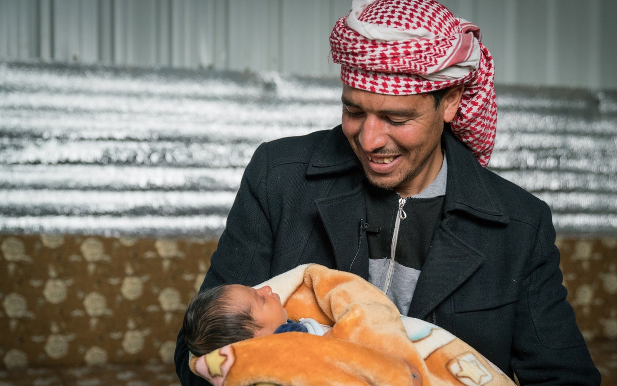 Father holds his newborn baby.