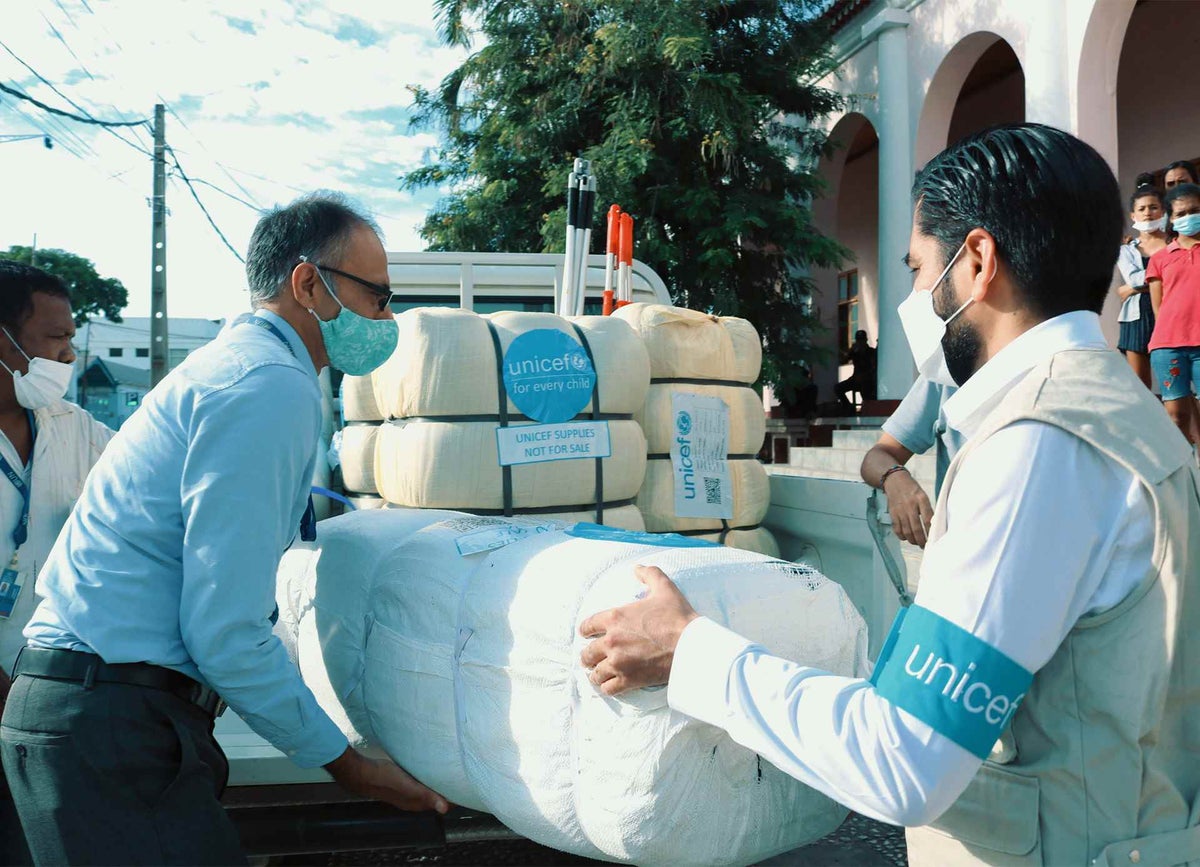 UNICEF team help unload relief items at a shelter for people displaced by flooding in Balide, Dili Municipality.