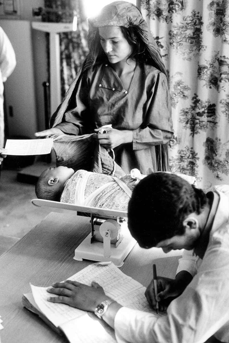 A woman stands next to her child during growth monitoring session in a health centre in Afghanistan in 1995. 