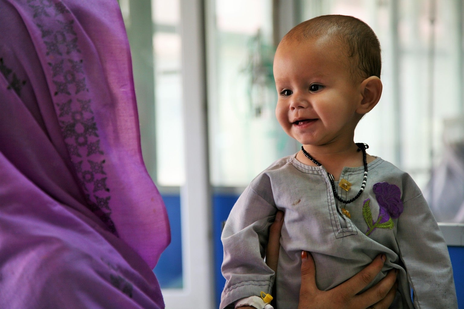 2 year old Samiullha smiles with his mother following UNICEF-supported in-patient treatment for severe acute malnutrition at Indira Gandhi Children’s Hospital in Kabul, Afghanistan.