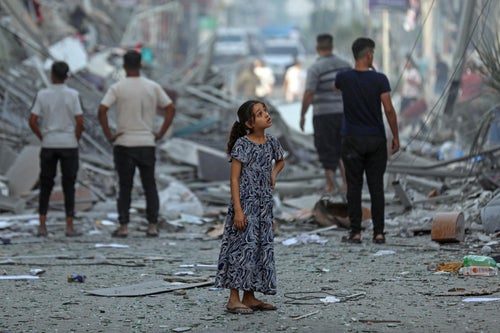 A girl standing amongst the rubble in Gaza