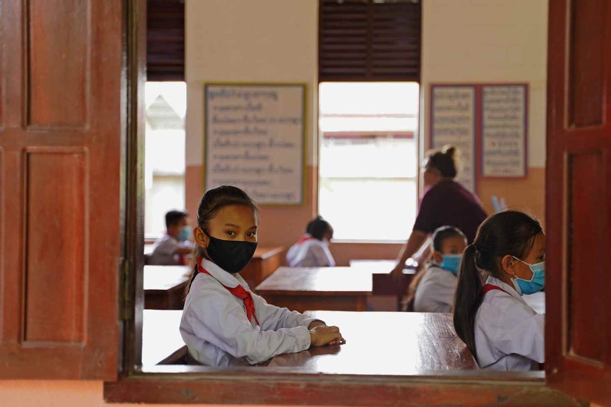 A girl looks out the window during class at a school in Laos. 