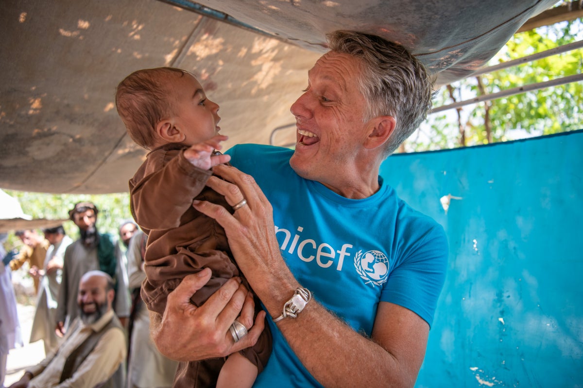 Smiling man holds young child