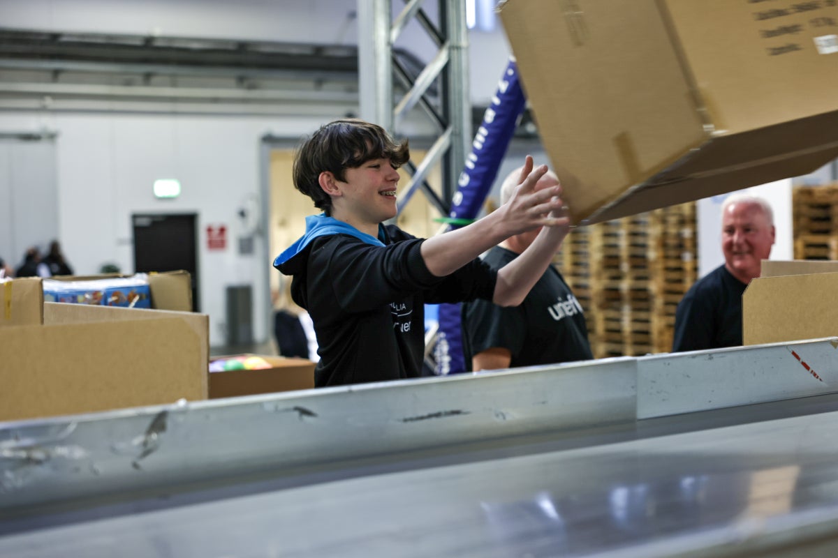 A young boy catching a large brown box.