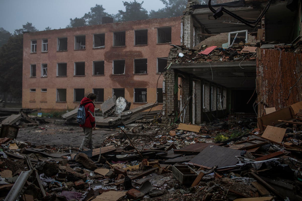 A young girl walks through the rubble of her school that was destroyed.
