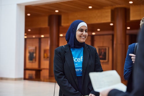 An UNICEF Young Ambassador standing and smiling 