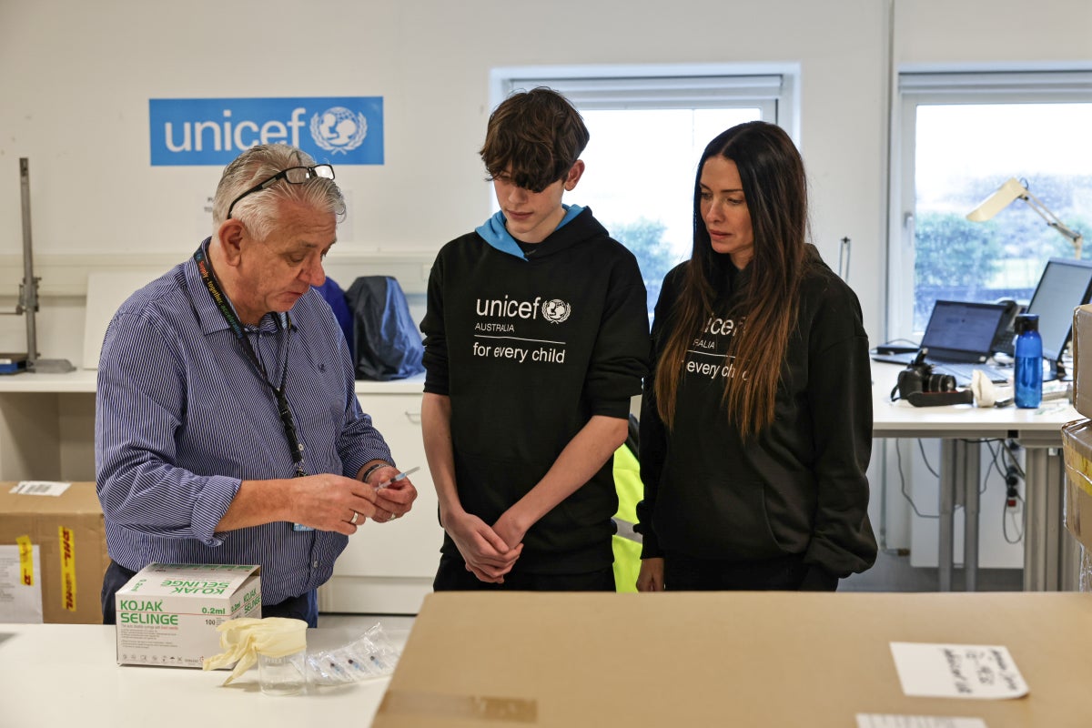 A mother and son being shown medical equipment in a room.