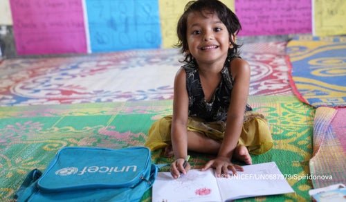Five-year-old Asma draws on the floor at the UNICEF kindergarten in the Rohingya refugee camps. 