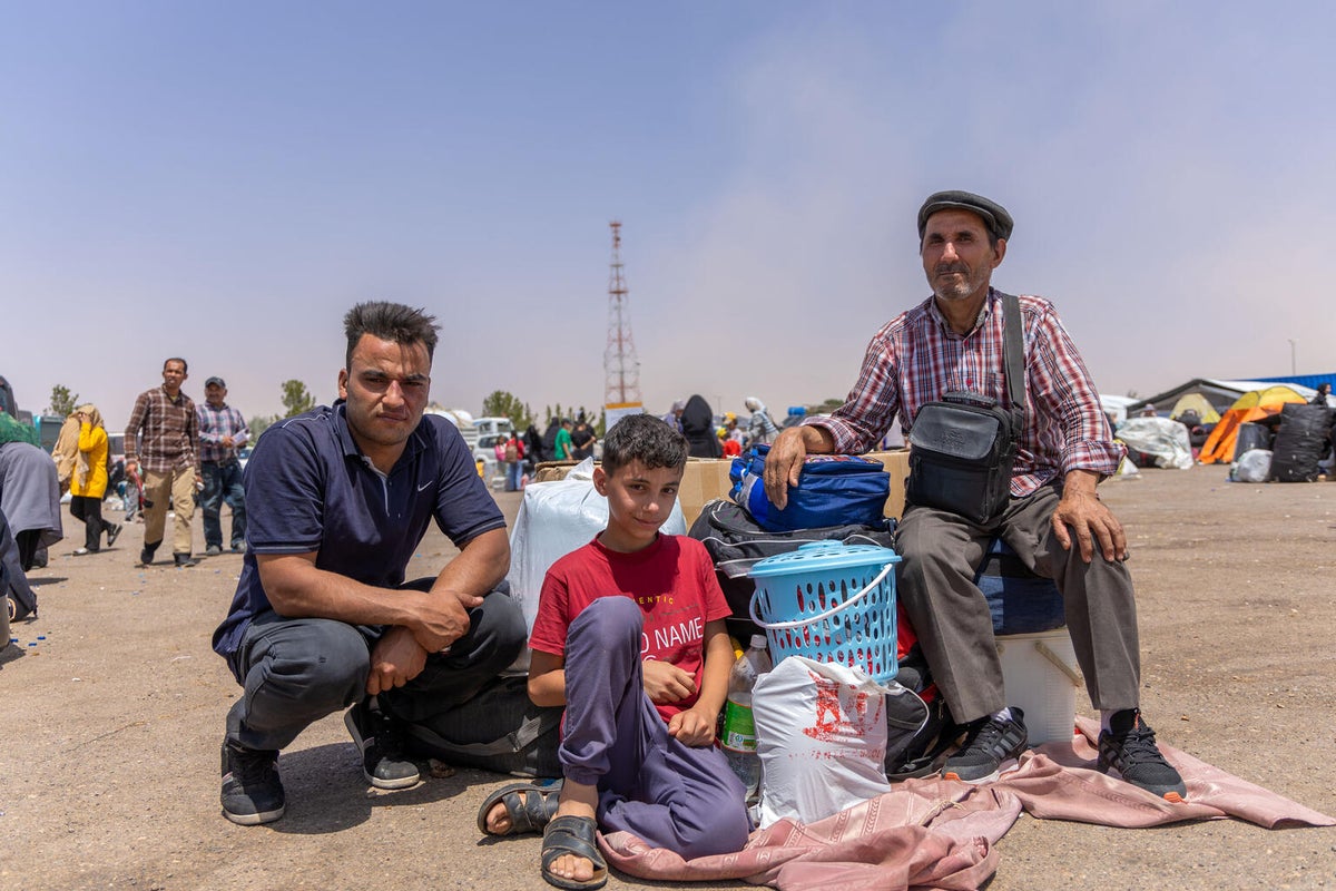 A father with two of his seven children at the border of Iran and Afghanistan.