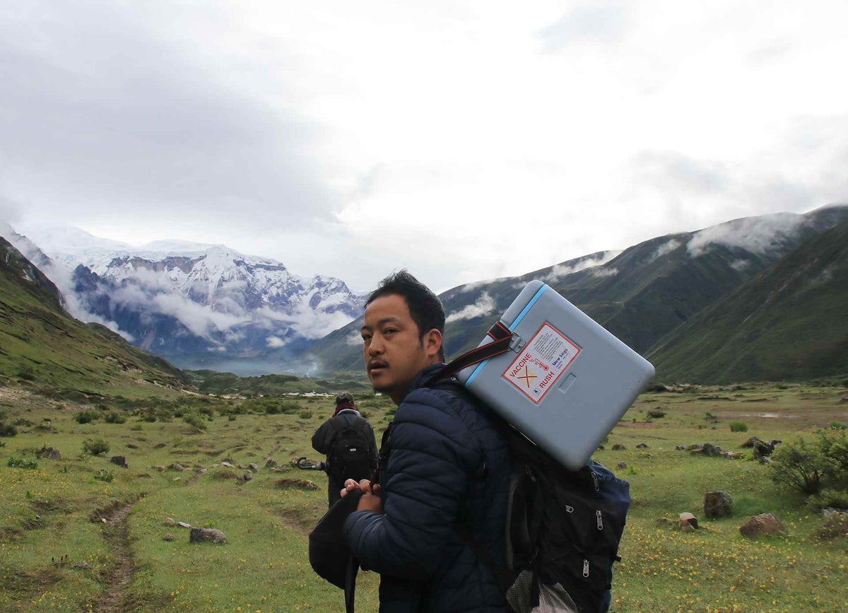 Health Assistant Dhan and his team walk through grasslands enroute to a village in Gasa district.