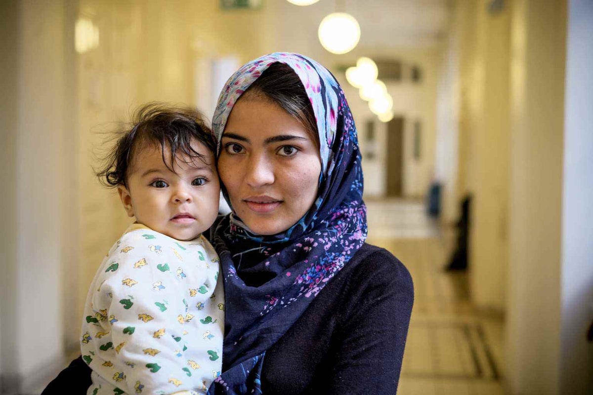 Young mother Zahra Husseini holds her baby daughter Xaineb in an emergency shelter in Vienna in 2015. They are refugees from Afghanistan. 