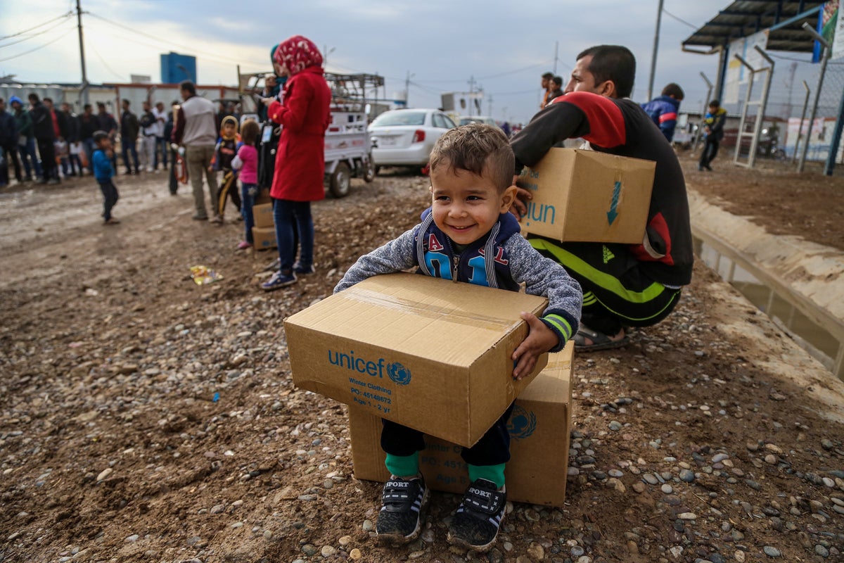 A young boy is holding a UNICEF branded box. He looks excited.