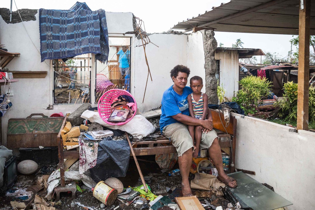 Kalisi holds her son Tuvosa and explains how he has changed since Cyclone Winston tore their house apart.