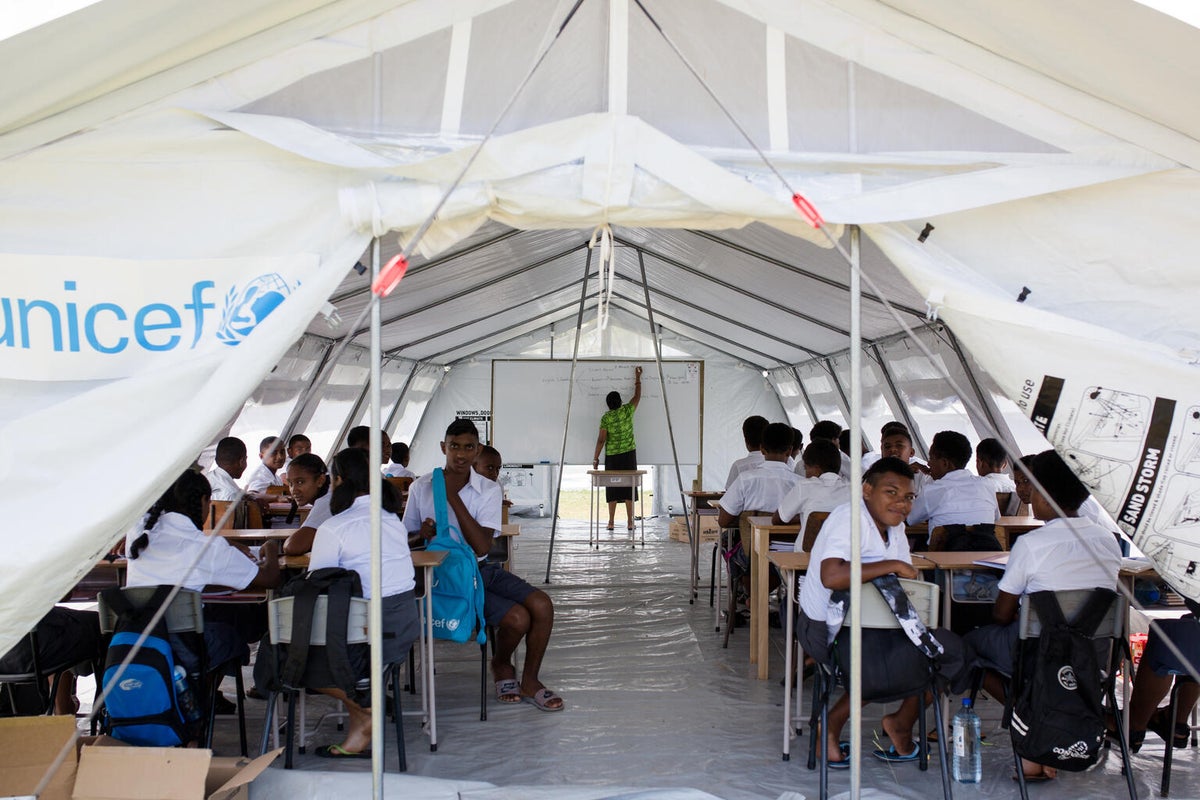 School children in Fiji learning in a UNICEF makeshift classroom after their school was destroyed from Hurricane Yasa.