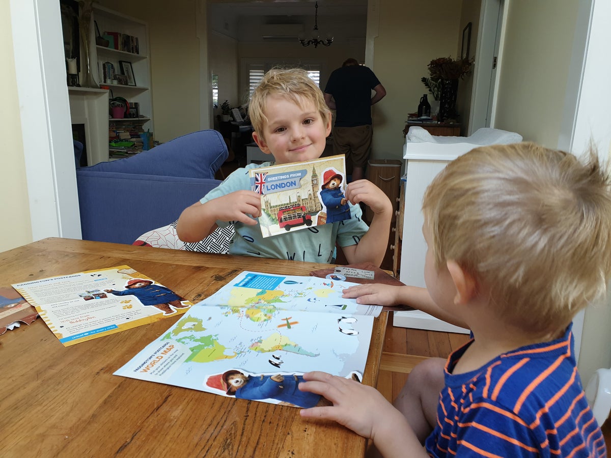 Two boys are playing with the postcards