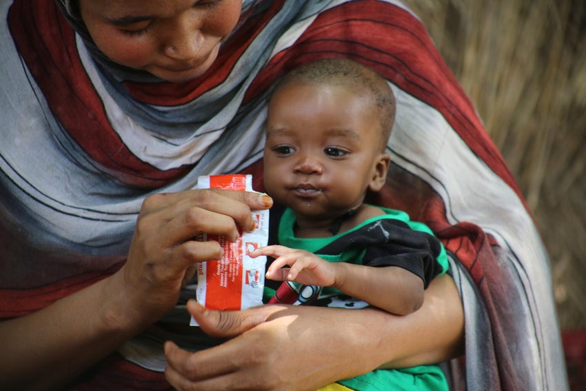 In Sudan, a mother feeds her six-month-old baby Ready-to-use therapeutic food (RUTF).