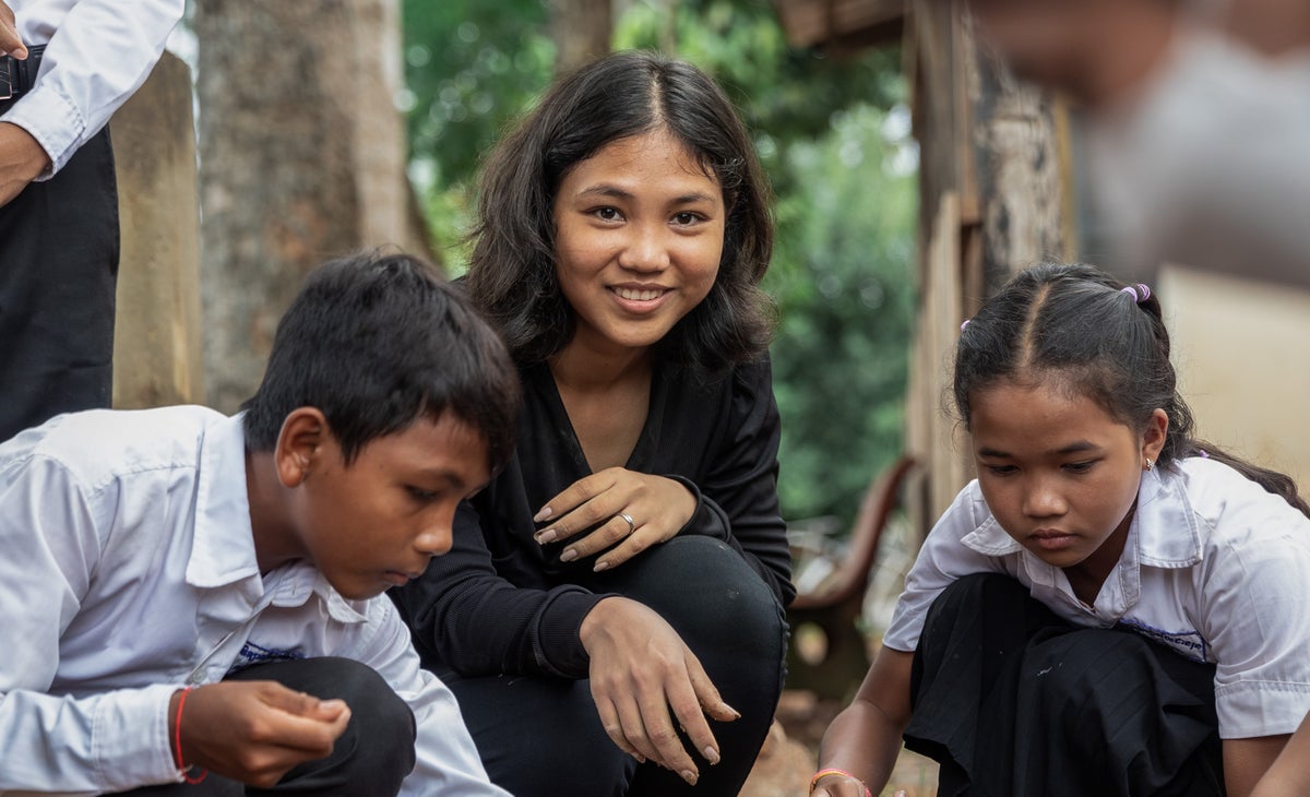 Young person working in garden with school students