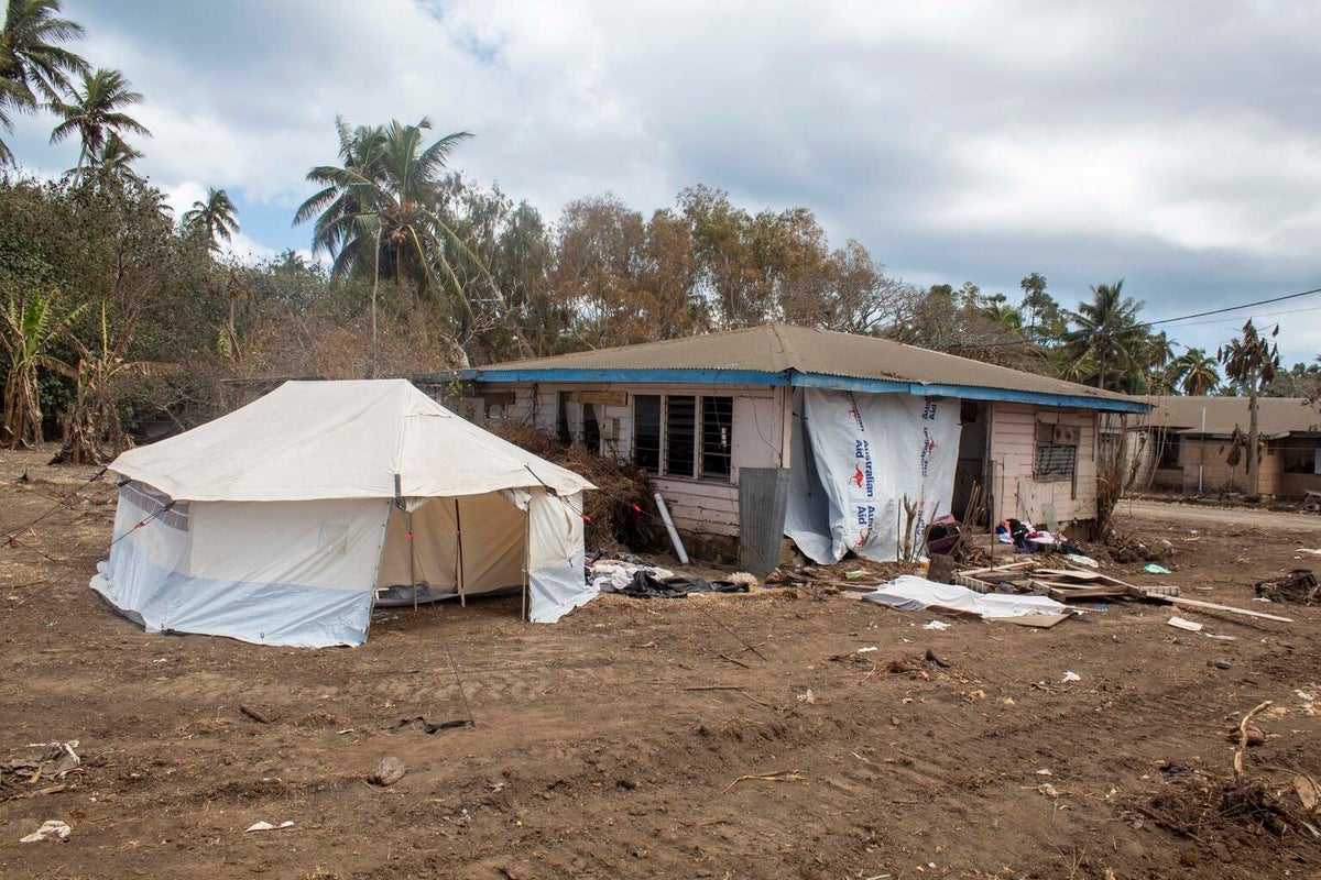 A house affected by the disaster. Next to it, there's an emergency tent.