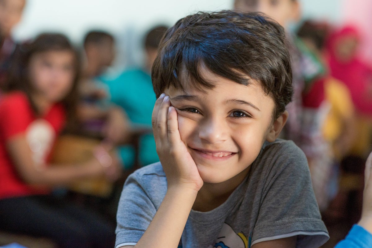 A young boy is smiling to the camera.