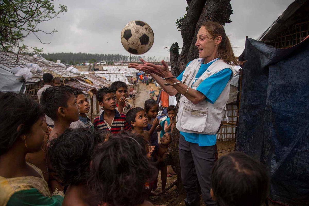 Krissie Hayes plays with Rohingya children following a downpour in Kutupalong refugee camp, Bangladesh