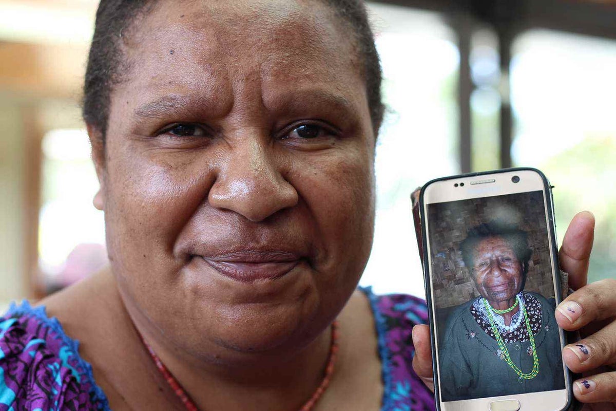 Josephine, 40, holds a photo of her mother, 64, who has been a powerful advocate against polygamy