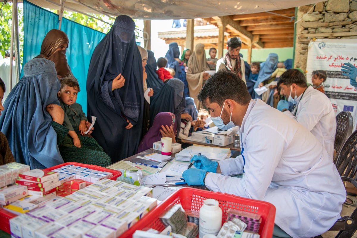 Health workers talk to families at a clinic in Afghanistan