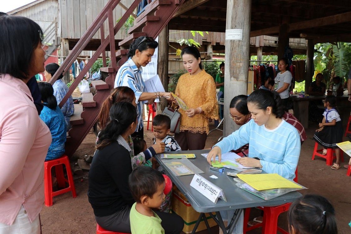 A MyHealth team member helps a participant and her children register.