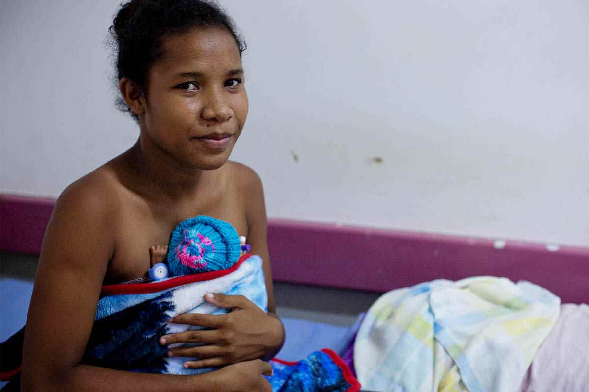 A mother at the Special Care Nursery in a Port Moresby hospital in Papua New Guinea provides Kangaroo Mother Care (skin to skin care) on her baby to keep it warm 