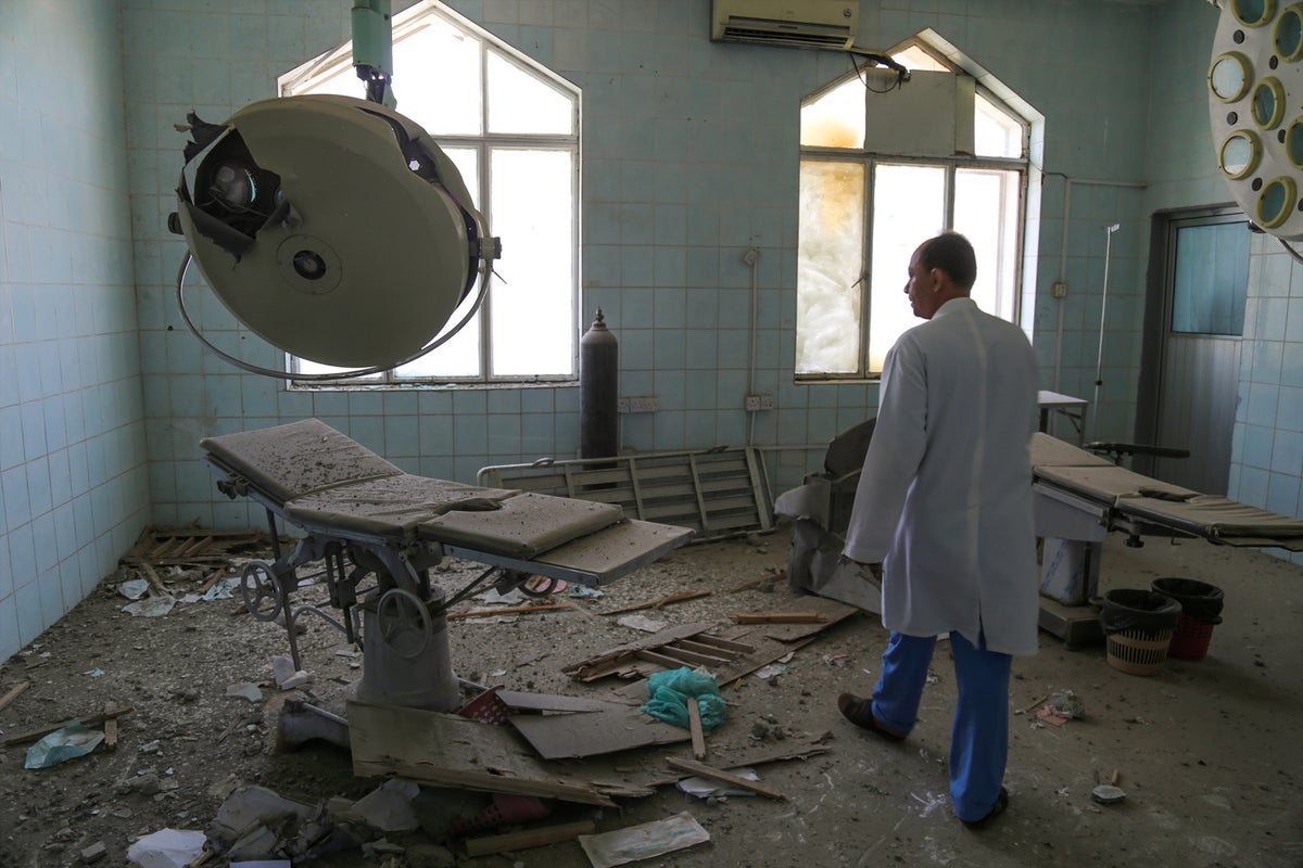 A doctor in Yemen walks through a destroyed hospital