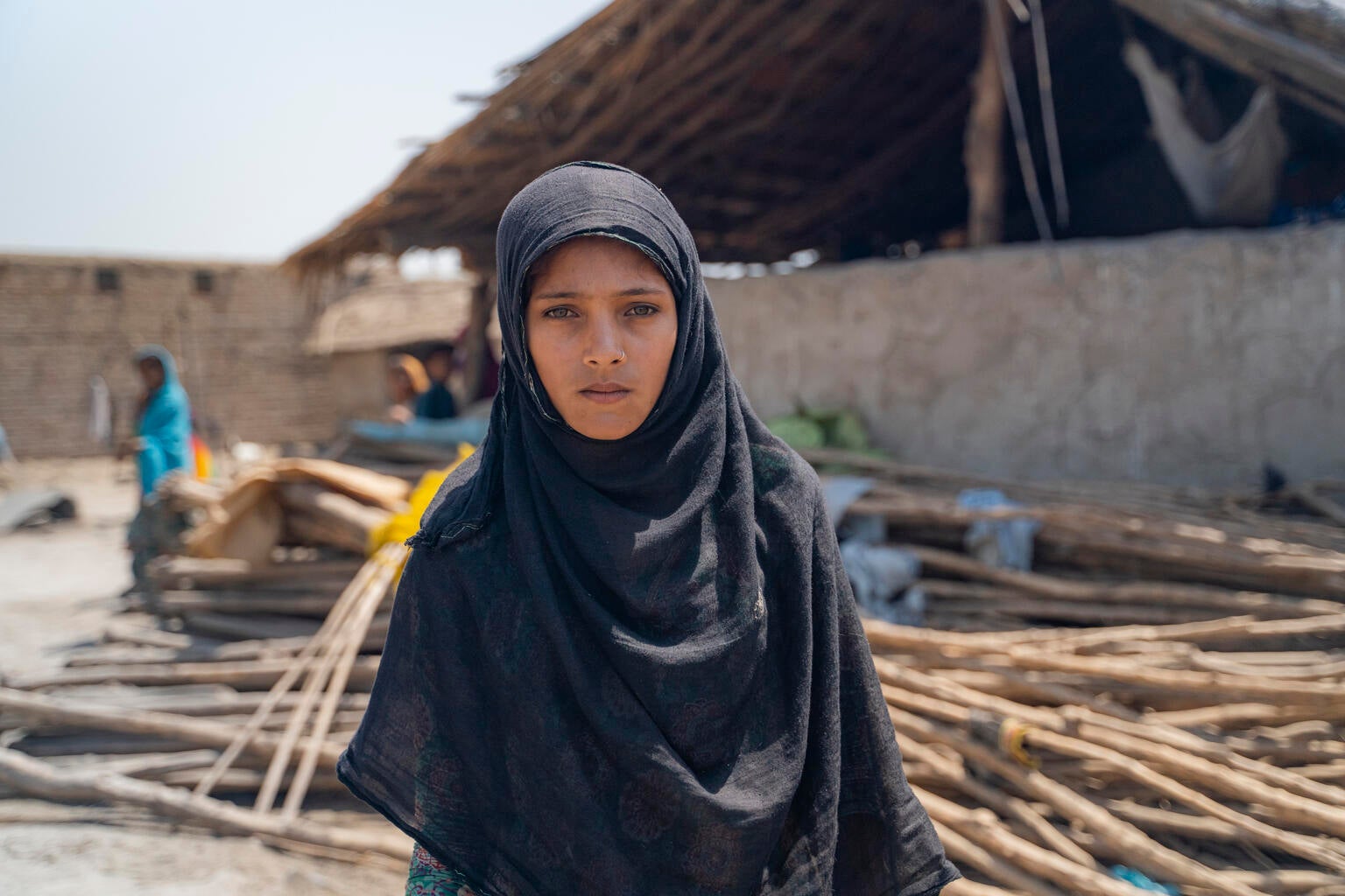 A young girl standing in front of her home that was destroyed during the floods in Pakistan.