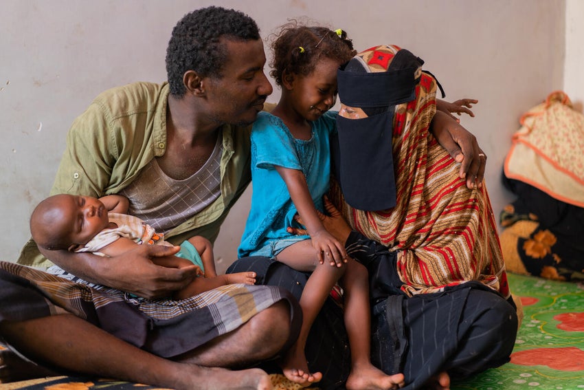 A young Yemeni family cuddling after they have immunized their children. 
