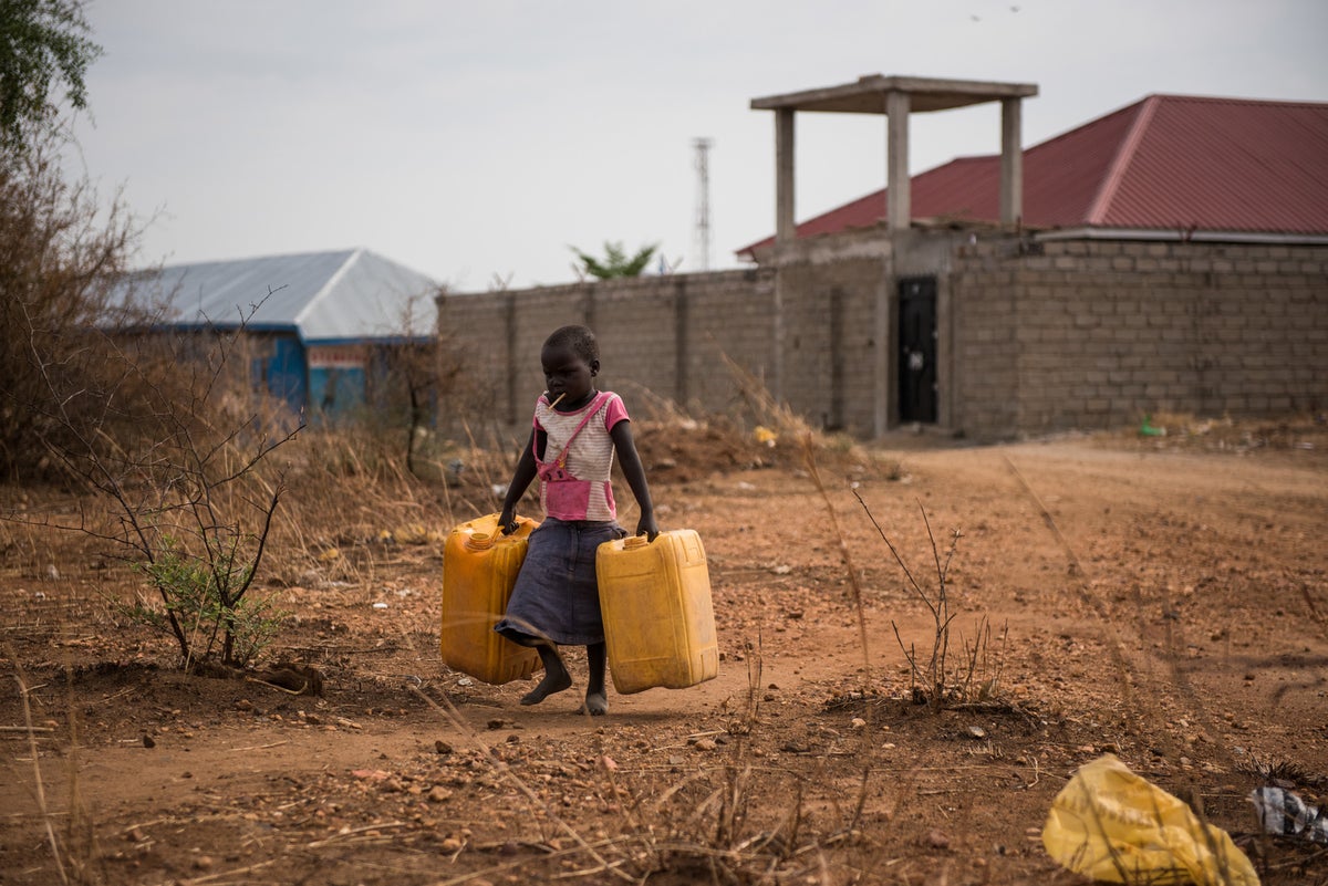 A child carryning empty jerry cans