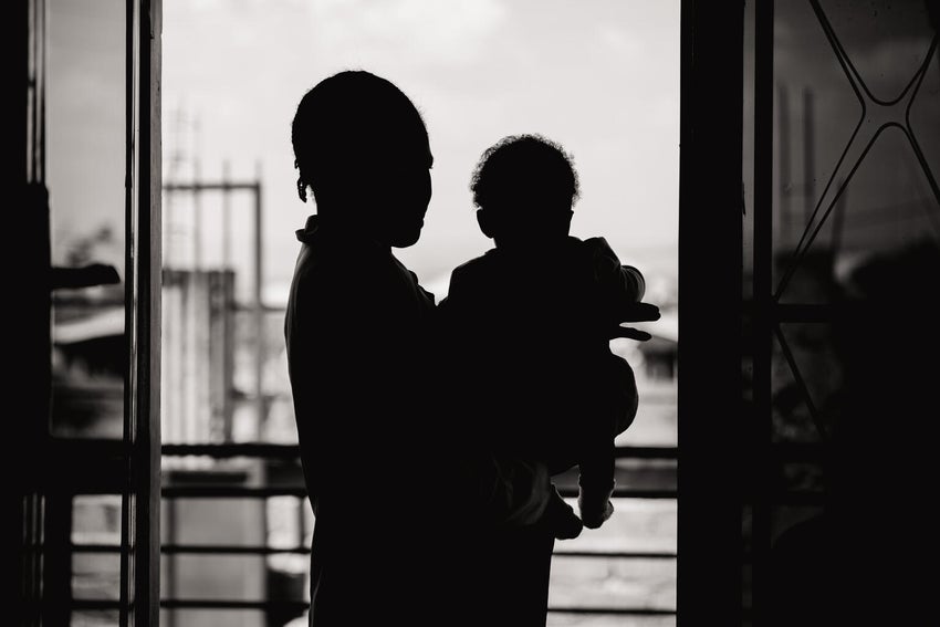 An 18-year-old mother of two holds her baby girl in DRC.