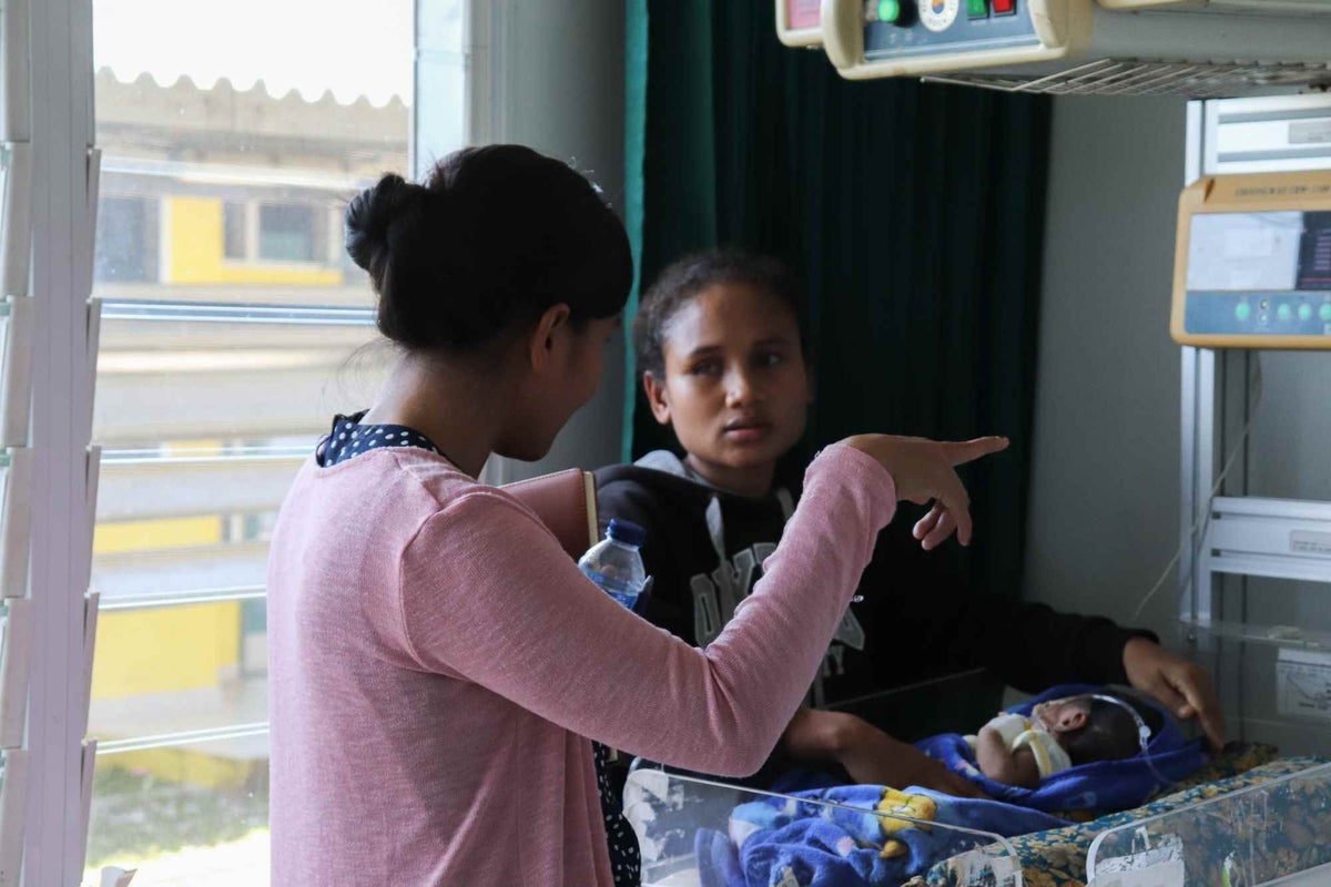 Jonia speaks with mother Zulmira, whose three-week-old son is receiving treatment at the Baucau Regional Hospital