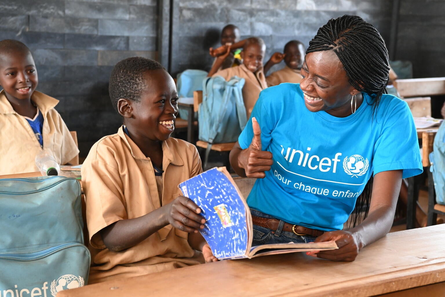 Fanta Kone, UNICEF Staff member, with some students attending class in a school made out of recycled plastic bricks, in Nabekounoubobo