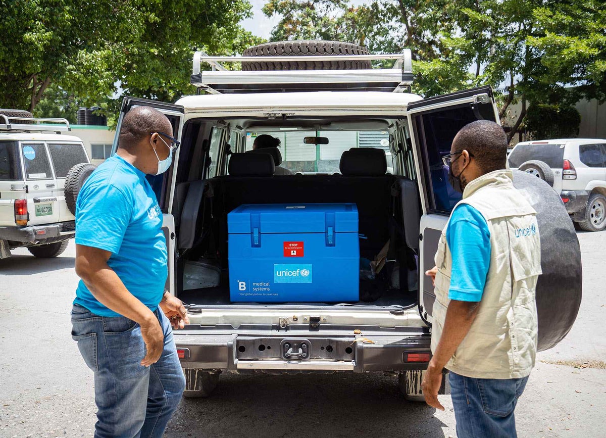 UNICEF Immunisation Specialists transport COVID-19 vaccines to a UNICEF solar-powered fridge in Haiti.