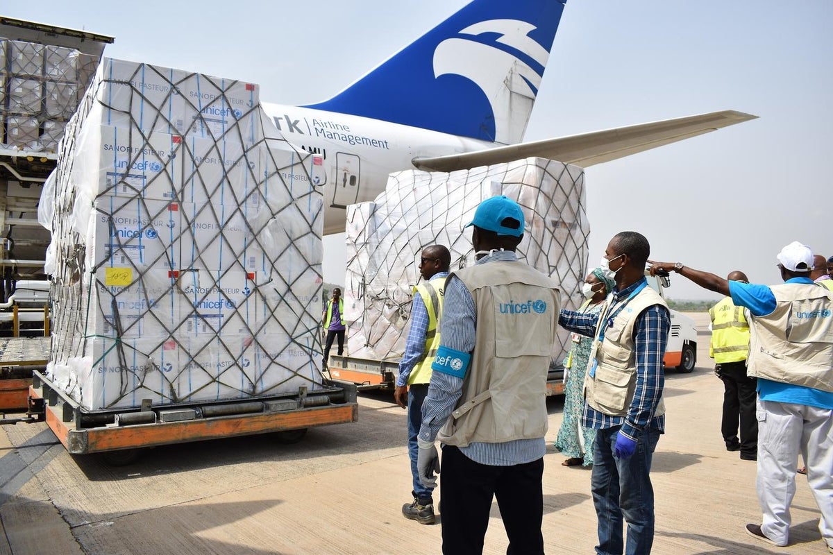 Pallets of boxes being unloaded from a plane.