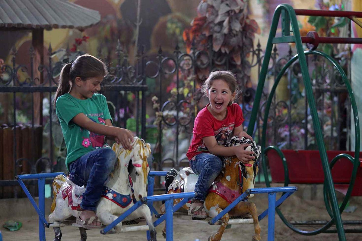 Two girls play at the 'Land of Childhood' underground playground in a besieged town in in the Syrian Arab Republic.
